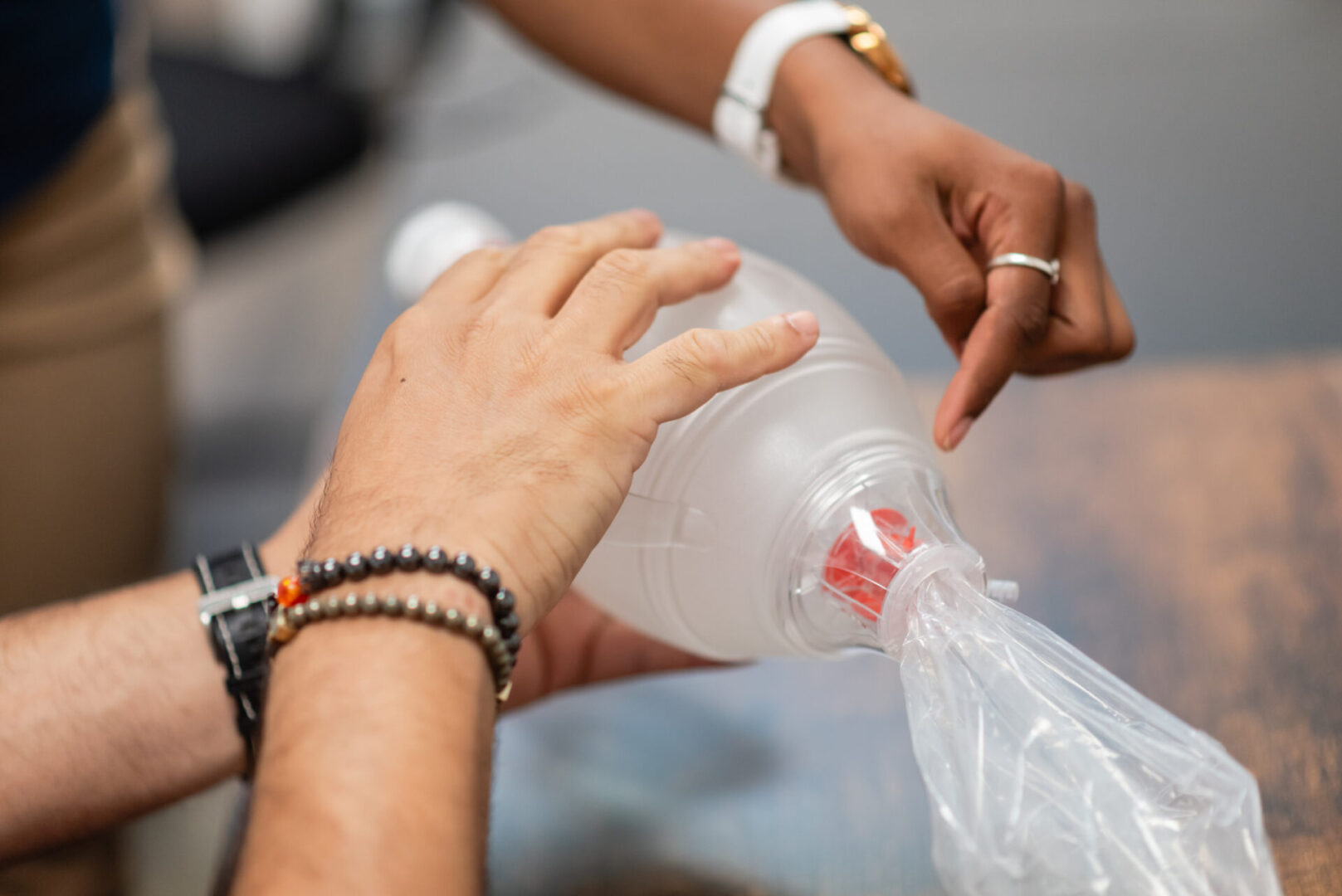 A person is pouring water into a plastic bottle.