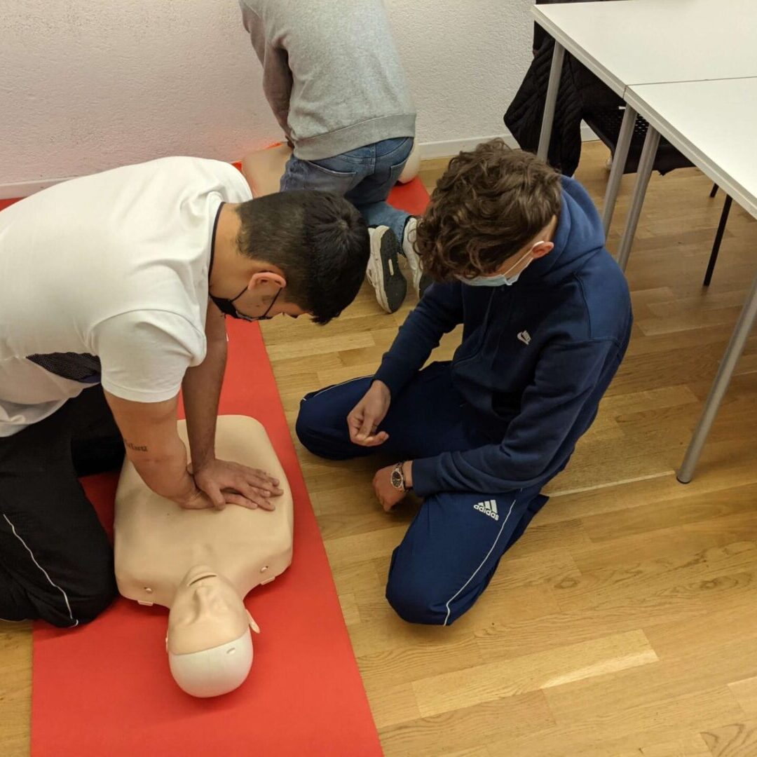 Two people practicing cpr on a dummy.